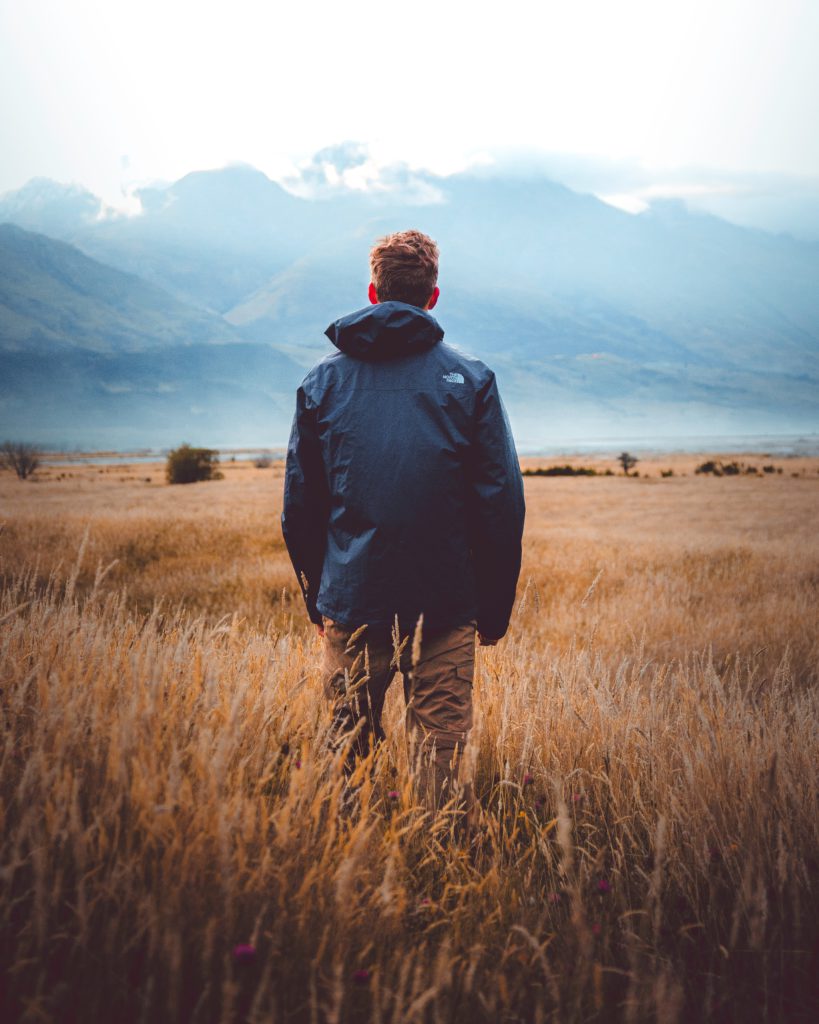 man in middle of wheat field